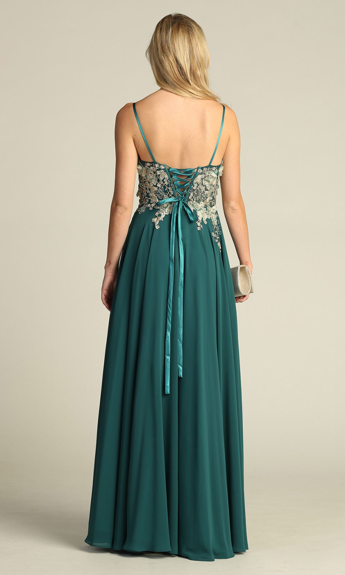 Woman wearing the Lace-Up Open-Back Long Prom Dress: Chicas C5124 in teal, featuring thin straps, lace-up back, and floral embroidered bodice. She holds a light-colored clutch and is shown from behind.